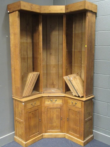 Lot 516 - A blonde oak corner bookcase, the open upper...