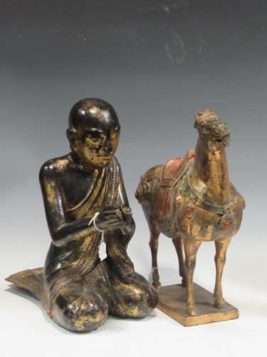 Lot 60 - An oriental carved wood and gilt figure of a...