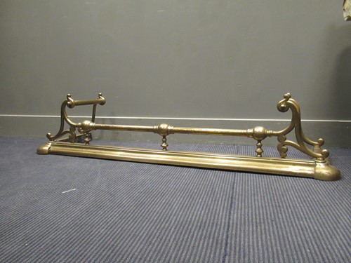 Lot 439 - A brass fender with scrolled end decoration...