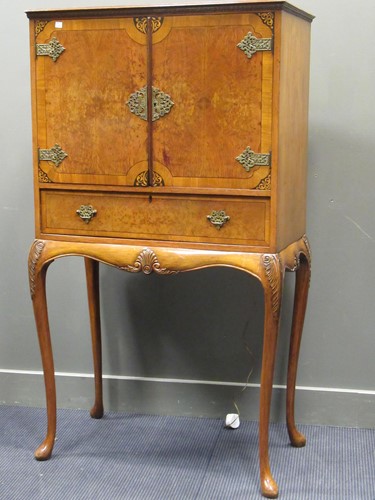 Lot 566 - A 1930's walnut cocktail cabinet, the pair of...