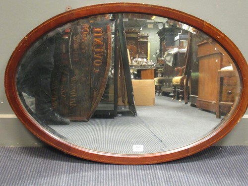 Lot 470 - An Edwardian mahogany oval wall mirror with...