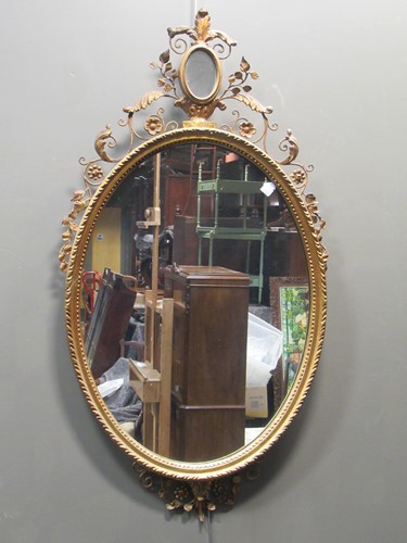 Lot 667 - An oval gilt wall mirror with flower and...