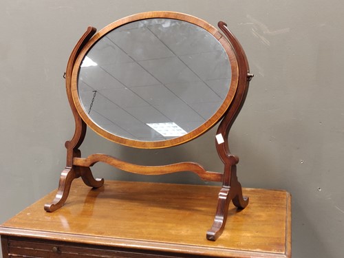 Lot 710 - A mahogany oval toilet mirror, and another...