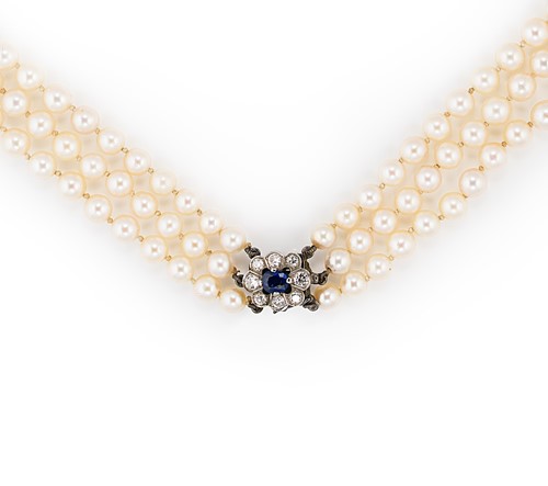 Lot 121 - A triple row of cultured pearls with a sapphire and diamond clasp