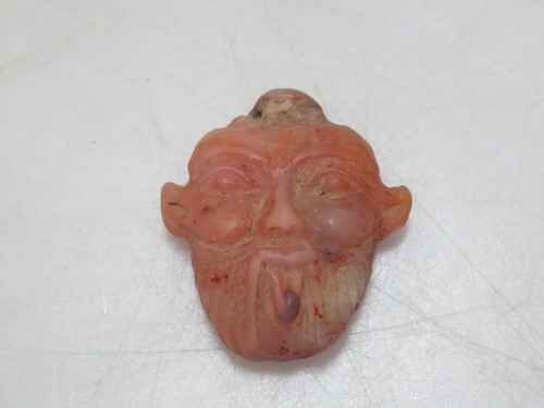 Lot 203 - A small pendant, carved with the head of an...