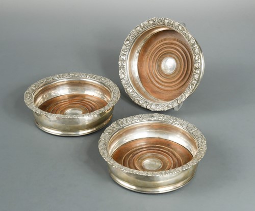 Lot 485 - A matching trio of George III silver bottle coasters