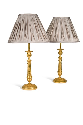Lot 319 - A pair of Regency engine turned ormolu candlestick lamps, circa 1820