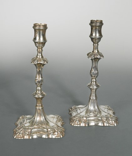 Lot 475 - A pair of George II cast silver candlesticks, mark of John Cafe