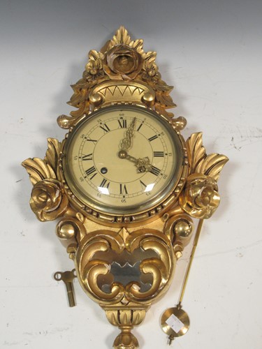 Lot 105 - A Swedish gilt wall clock, 52cm high