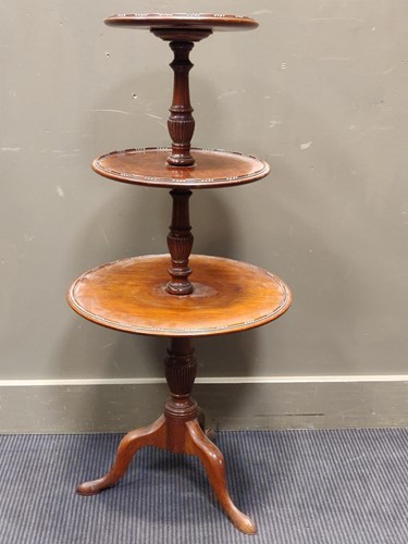 Lot 522 - A mahogany circular three tier dumb waiter in...
