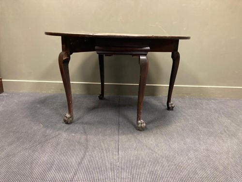 Lot 523 - An oval drop leaf table with carved lion-paw...