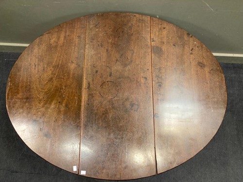 Lot 523 - An oval drop leaf table with carved lion-paw...