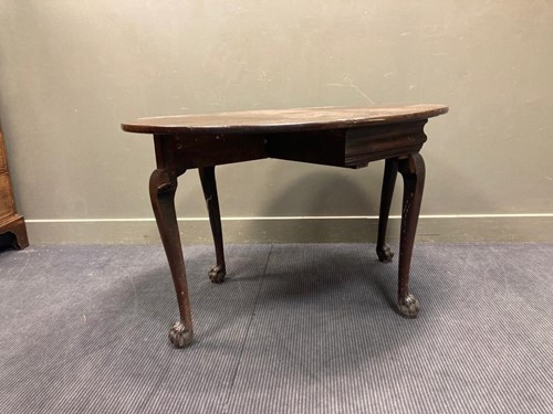 Lot 523 - An oval drop leaf table with carved lion-paw...