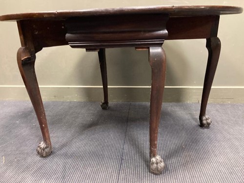 Lot 523 - An oval drop leaf table with carved lion-paw...