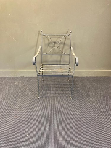 Lot 703 - A wrought iron garden elbow chair