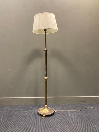Lot 516 - A brass standard lamp with lion paw feet,...
