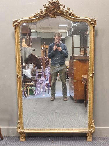 Lot 664 - An arched gilt wall mirror surmounted by a...