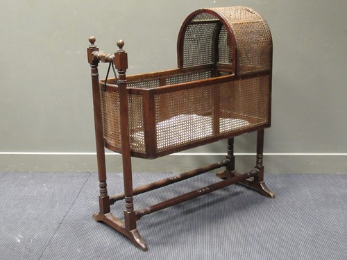 Lot 516 - A 19th century caned rocking cradle with a...