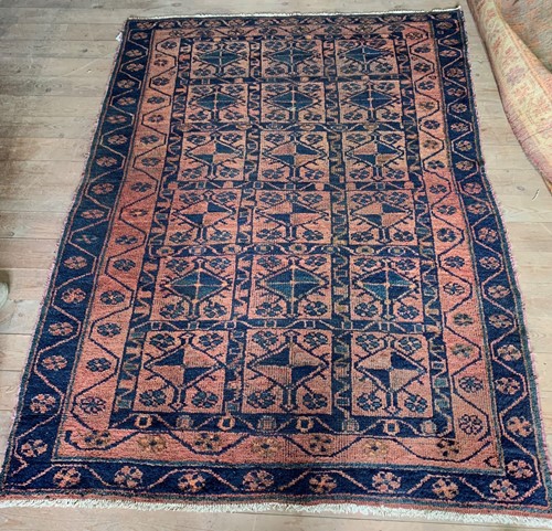 Lot 612 - A Belouch wool tribal rug with madder field with three rows of blue lozenges