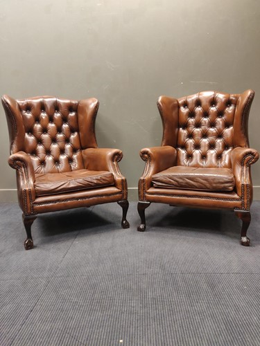 Lot 669 - Pair of wingback armchairs with faux leather...