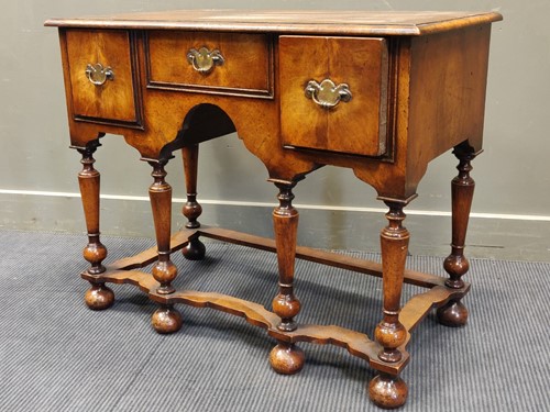 Lot 544 - A walnut lowboy, the rectangular top over an...
