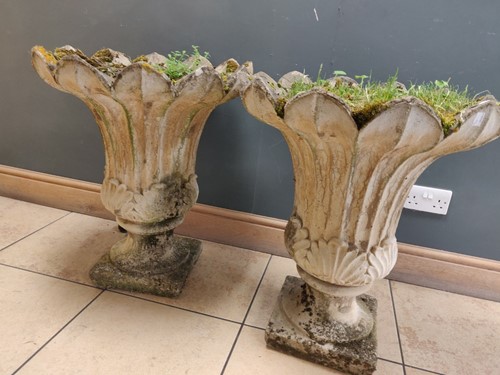 Lot 664A - A pair of composite tulip shaped garden urns...