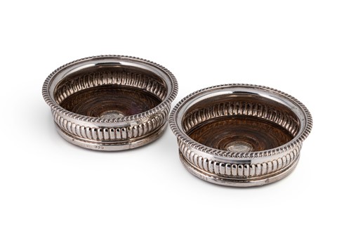Lot 553 - A pair of George III silver bottle coasters