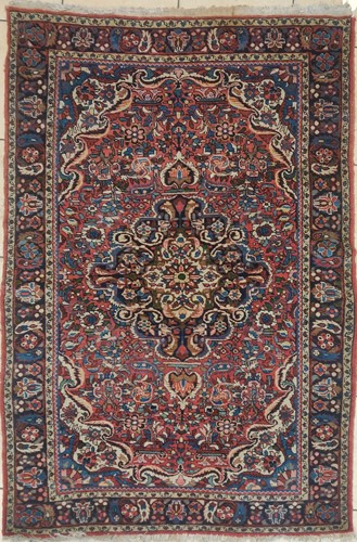 Lot 604 - A Persian red ground rug with central...