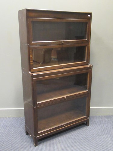 Lot 476 - A 1930s oak stacking glazed sectional bookcase,...