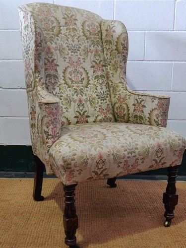 Lot 547 - A faux-rosewood wingback armchair raised on...
