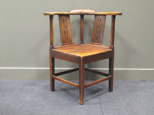 Lot 480 - An 18th century elm seated corner chair, the...