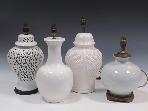 Lot 585 - A group of four white china baluster lamps,...