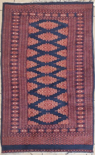 Lot 610 - A red ground rug with blue central motif...