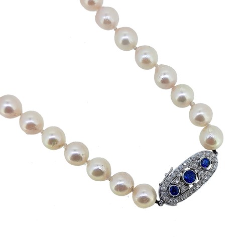Lot 244 - A single row of pearls with a sapphire and diamond clasp