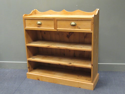 Lot 464 - A pine open bookcase with a pair of frieze...