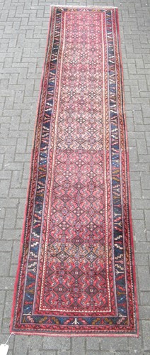 Lot 602 - A red ground runner with blue border, 430 x 92cm