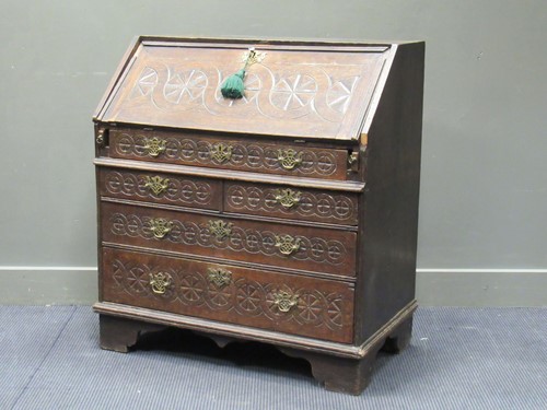 Lot 489 - A carved oak bureau in the Gothic style, the...