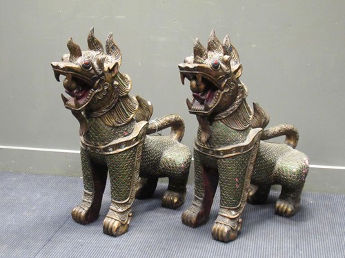 Lot 444 - A pair of Eastern carved wood mythical dogs...