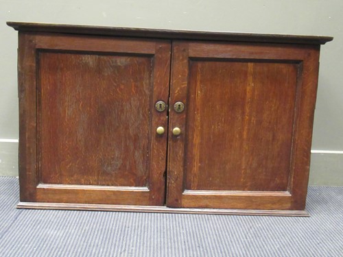 Lot 397 - An oak cabinet, the two panelled doors...