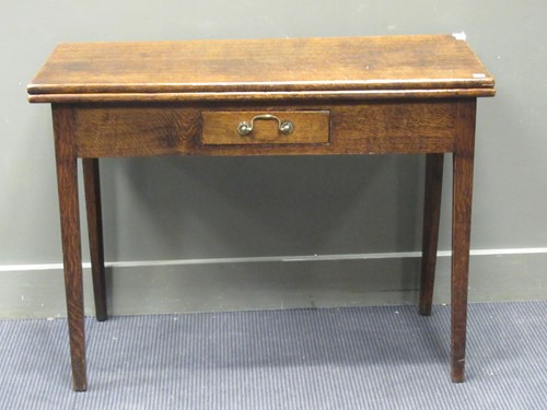 Lot 389 - An oak fold over tea table with single frieze...