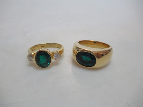 Lot 158 - Two synthetic emerald rings stamped '18K',...