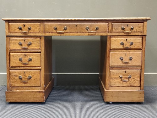 Lot 322 - An oak pedestal desk with a leather top...
