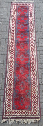 Lot 509 - A red ground runner, with diamond pattern...