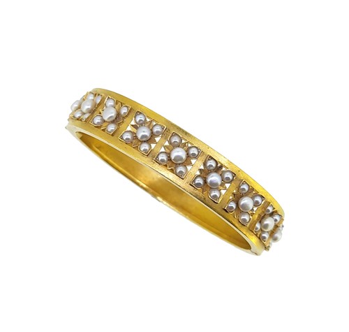 Lot 143 - A cased early 20th century pearl set hinged bangle