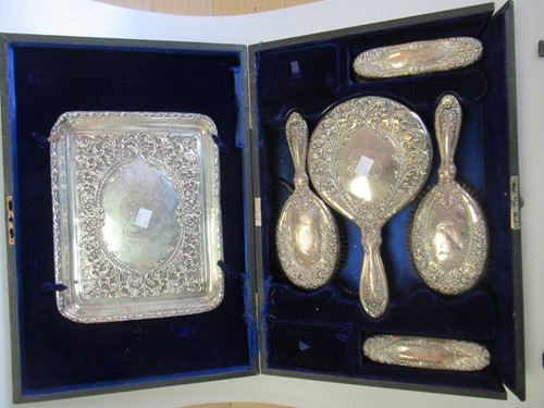 Lot 245 - A cased dressing table set comprising silver...
