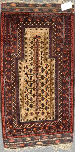 Lot 23 - A late 19th century Beluchi prayer rug with...