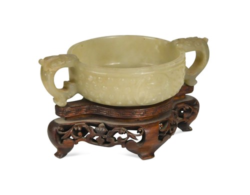 Lot 69 - A Chinese jade tab-handled bowl in an archaic style, Qing Dynasty, 19th century