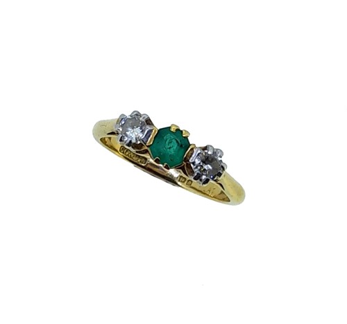 Lot 179 - A late 20th century three stone emerald and diamond ring