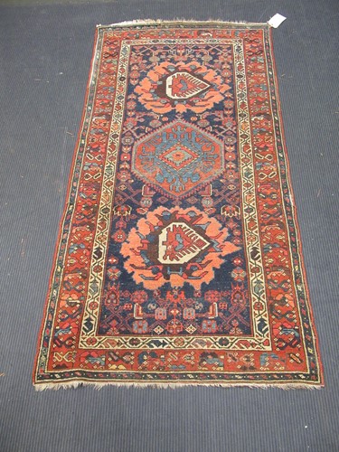 Lot 568 - A woolen blue ground rug with red border and...
