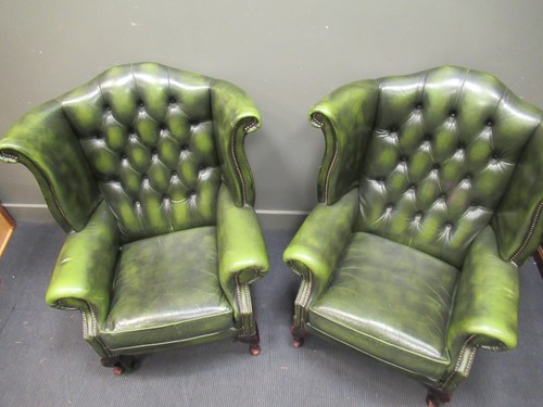 Lot 425 - A pair of wing back armchairs with green...